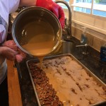 Pouring the caramel over the pecans.